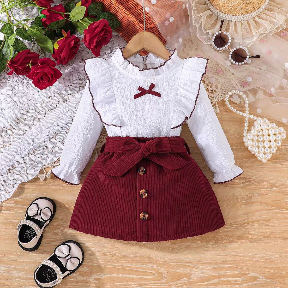 طقم من قطعتين (بلوزة كشكش بيضاء وتنورة كوردروي بفيونكة)